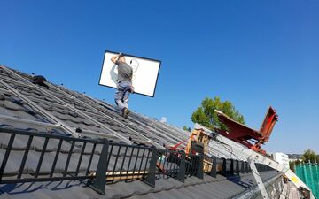 Verlegen der Solarmodule auf dem Dach des neuen Mieterstromprojekts in Weimar